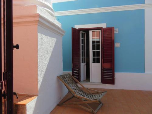 a chair sitting on the porch of a house at Pátio das Andorinhas in Ferreira do Alentejo