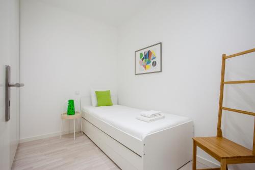- un canapé blanc dans une chambre blanche avec une chaise dans l'établissement Liiiving in Porto | Santa Catarina Cosy Apartment, à Porto