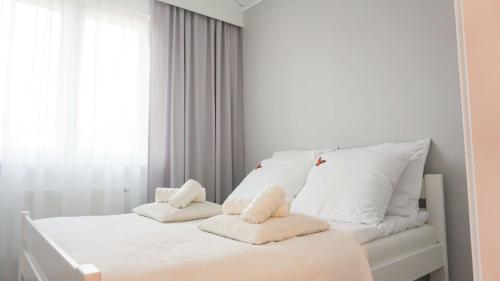 ゴジュフ・ヴィエルコポルスキにあるApartament Olimpのベッドルーム1室(白いベッド1台、タオル付)
