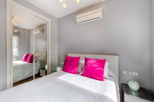 マラガにあるLa Rubia Mercedesのベッドルーム(ピンクの枕が付く大きな白いベッド付)