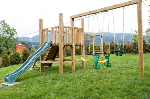 a playground with two swings and a slide at Hotel Bromont in Bromont