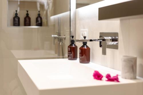 a bathroom sink with two bottles of wine on it at The View Luxury Apartments Taormina in Taormina