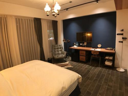 une chambre d'hôtel avec un lit et un bureau dans l'établissement Mr. Buster B&B, à Hualien