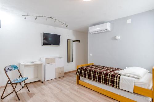 a bedroom with a bed and a desk and a chair at 2 Apartmans "Metro" and "Gum" in Split