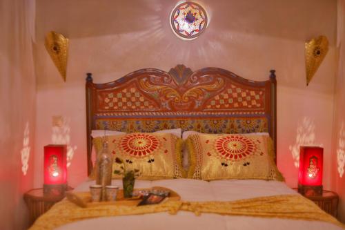 a bedroom with a large bed with two red candles at Riad Las Mil y una Noches Tetuan in Tetouan