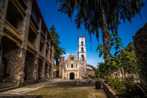 an old building with a tower in the distance at Hacienda Santa Maria Regla in Huasca de Ocampo