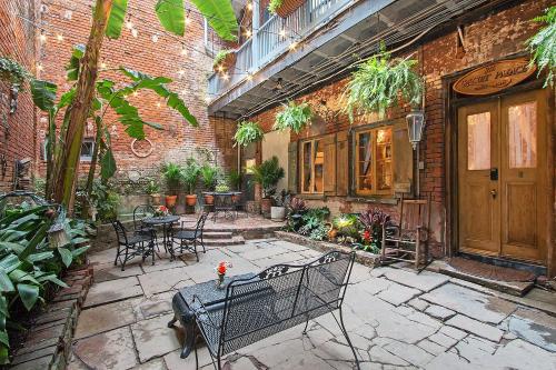 een patio met tafels en stoelen in een bakstenen gebouw bij French Quarter Mansion in New Orleans