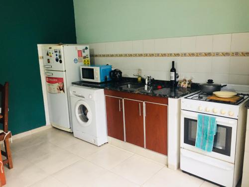 a kitchen with a stove and a refrigerator and a washing machine at Departamento-Casa-Marcos in La Plata