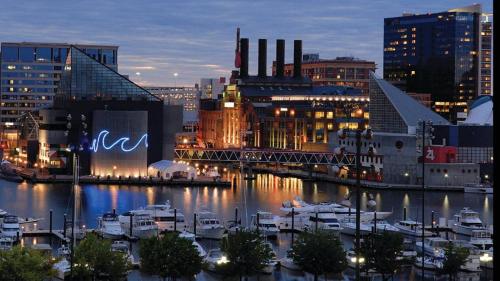 a city at night with boats in a harbor at Four Seasons Baltimore in Baltimore