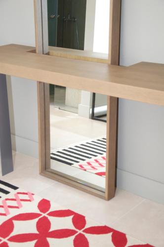 a mirror in front of a dressing table with a red rug at Ino Hotel & Suites in Samos