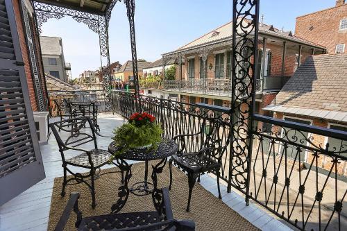 a balcony with chairs and a table with flowers on it at French Quarter Mansion in New Orleans