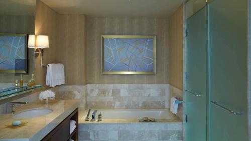 a bathroom with a tub and a sink and a shower at Four Seasons Baltimore in Baltimore