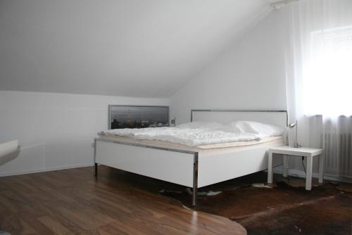 - une chambre blanche avec un lit et une fenêtre dans l'établissement Pension am Kurpark, à Waldbronn
