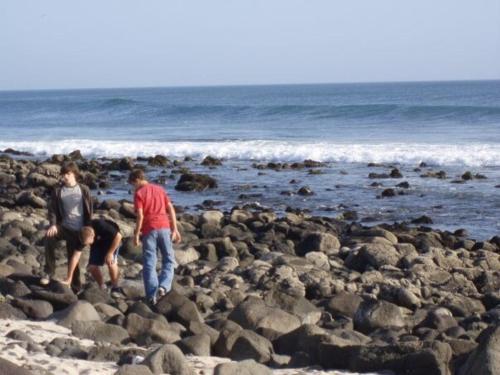 a group of people standing on a rocky beach at Maison d'Hôtes entière Cité Douane Golf Dakar in Dakar