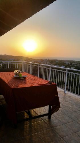 a table on a balcony with the sunset in the background at Alexandra Homestay in Kalavárda