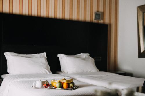 a tray of fruit on a plate on a bed at Areos in Athens