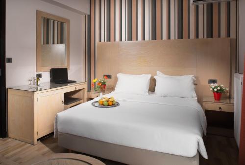 a bedroom with a large bed with a plate of fruit on it at Areos in Athens