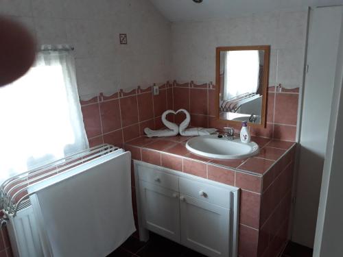 ein Bad mit einem Waschbecken und einem Spiegel in der Unterkunft Rózsa apartman in Lenti