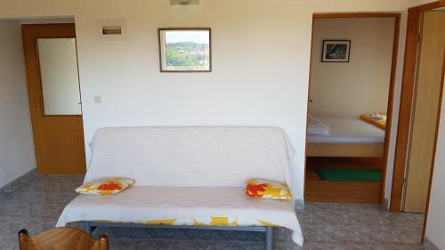a small white bed with two pillows on it at Cozy apartment in Jezera
