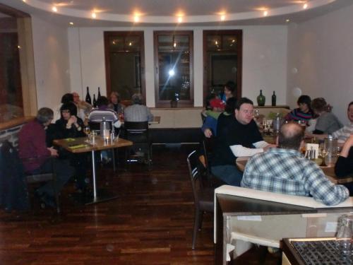 a group of people sitting at tables in a restaurant at Hotel Deutsches Haus in Kaub