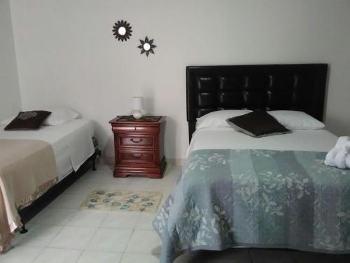 a bedroom with two beds and a wooden night stand at Casa De Polita in San Andrés