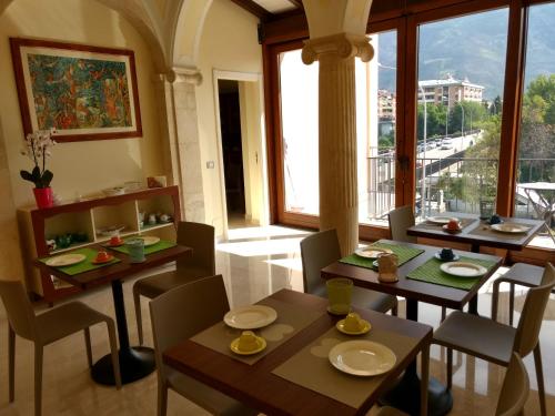 ein Esszimmer mit Tischen und Stühlen und einem großen Fenster in der Unterkunft B&B Ponte Capograssi in Sulmona