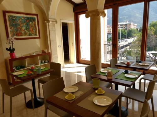 a dining room with tables and chairs and a large window at B&B Ponte Capograssi in Sulmona