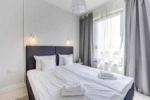 a bedroom with a large bed with two towels on it at GRANO APARTMENTS Gdańsk Motława SPA & Wellness in Gdańsk