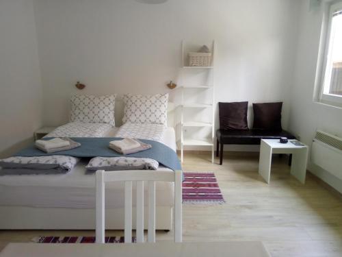1 dormitorio blanco con 1 cama y 1 silla en Yasmin, en Sarajevo