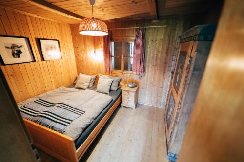 a small bedroom with a bed in a wooden room at Zauberhuette Wildschoenau in Oberau