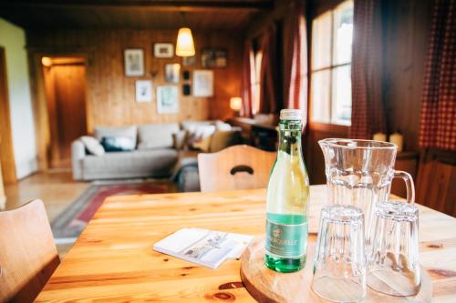 una botella de vino en una mesa de madera con copas en Zauberhuette Wildschoenau, en Oberau