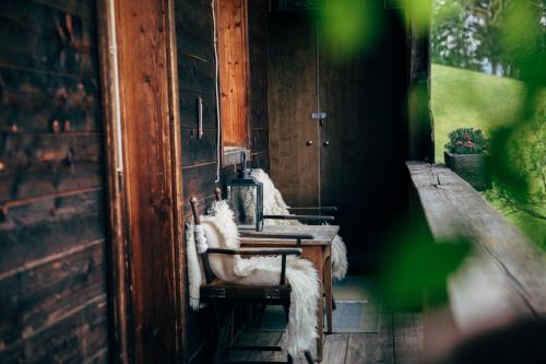 a room with a table and chairs on a porch at Zauberhuette Wildschoenau in Oberau