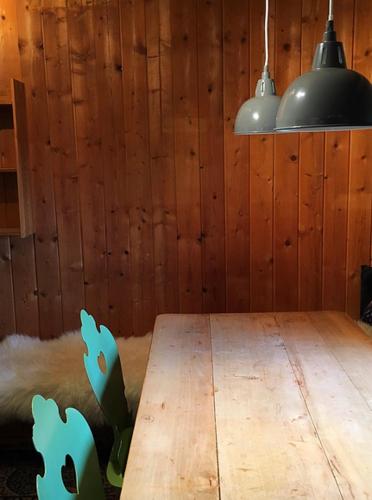 a dining room with a wooden table and two lights at Zauberhuette Wildschoenau in Oberau