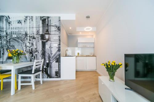 a kitchen and living room with a dining room at GRANO APARTMENTS Gdańsk Motława SPA & Wellness in Gdańsk