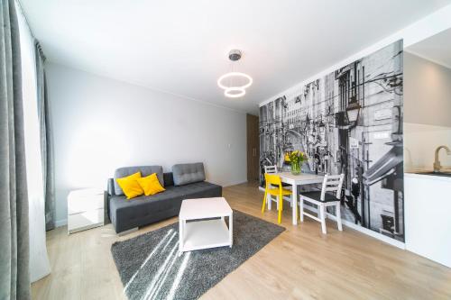 a living room with a couch and a table at GRANO APARTMENTS Gdańsk Motława SPA & Wellness in Gdańsk