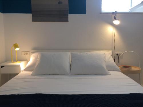 a bedroom with a bed with white sheets and a lamp at Apartment P 35 in Dubrovnik