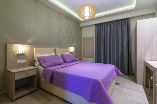 a bedroom with a purple bed with a purple blanket at Villa Regina in Keri