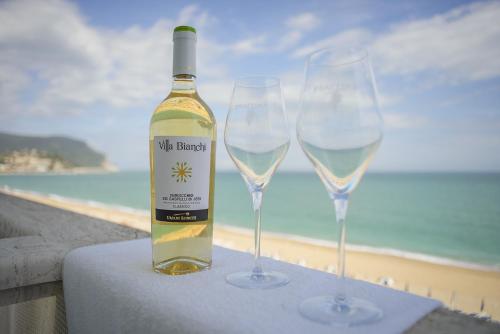 a bottle of wine and two wine glasses on a table at Hotel Marcelli in Numana