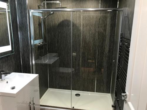 a glass shower in a bathroom with a sink at Corrieview Barn in Fort William