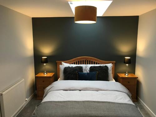 a bedroom with a bed with a dark green wall at Corrieview Barn in Fort William