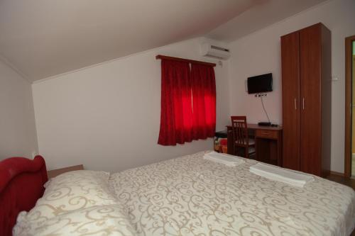 a bedroom with a bed and a red window at Ninkovic in Trebinje