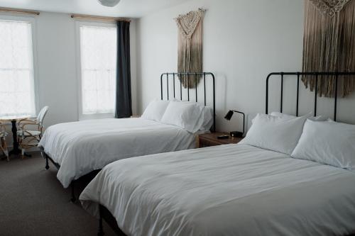 two beds in a hotel room with white sheets at Surf Hotel & Chateau in Buena Vista