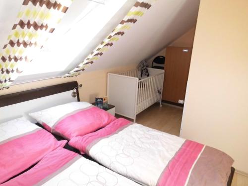 ノルトダイヒにあるCarmen u. Rudolf Lutzのベッドルーム1室(ピンクと白のシーツが備わるベッド1台付)