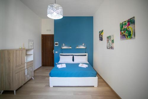 een blauwe slaapkamer met een bed en een blauwe muur bij Isola Blu in Siracusa