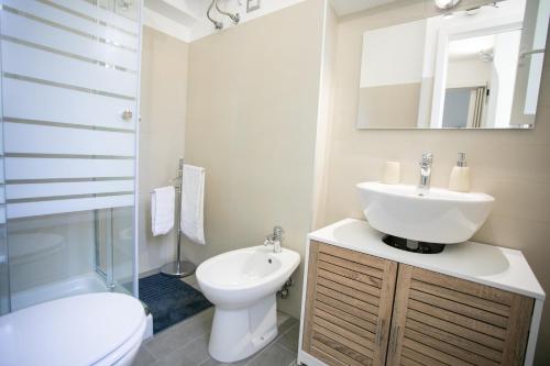 a bathroom with a sink and a toilet and a mirror at Isola Blu in Siracusa