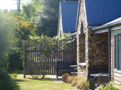 a wooden gate to a house with chairs and flowers at Hanmer Springs Scenic Views Motel in Hanmer Springs