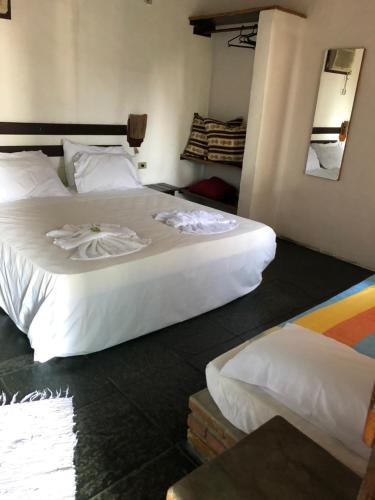 Habitación de hotel con 2 camas y espejo en Pousada Conde do Mar, en Ilhabela