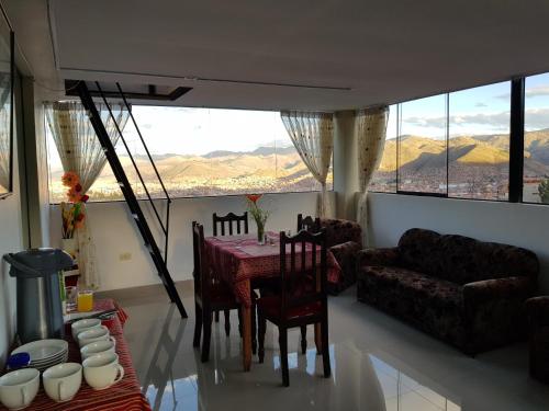 a living room with a table and chairs and a couch at Feliz Vista Casa-Hospedaje in Cusco