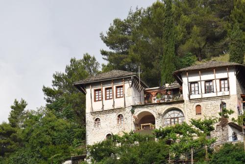 a house on top of a hill with trees at Guest House Salaria in Gjirokastër