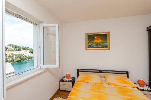 sypialnia z łóżkiem i dużym oknem w obiekcie Apartments Marinko w mieście Splitska